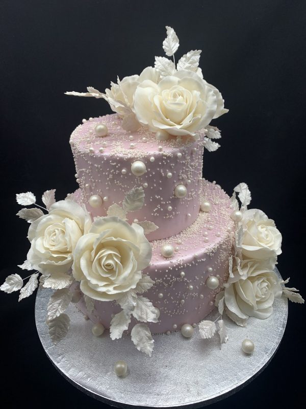 Dviejų aukštų rožinis tortas su cukrinėmis rožėmis